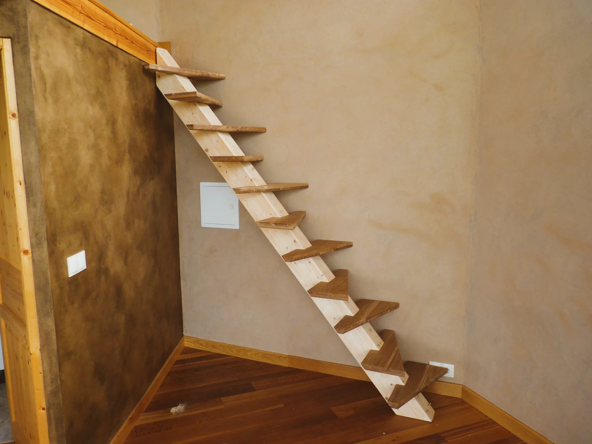 Escalier à pas japonais en chêne chocolat sur limon central, dans une pièce octogonale